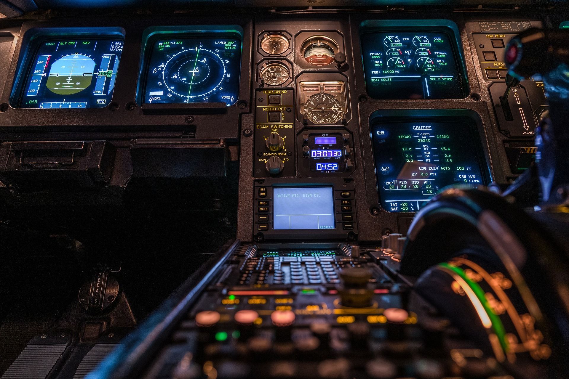 Airliner cockpit at night with illuminated flight displays
