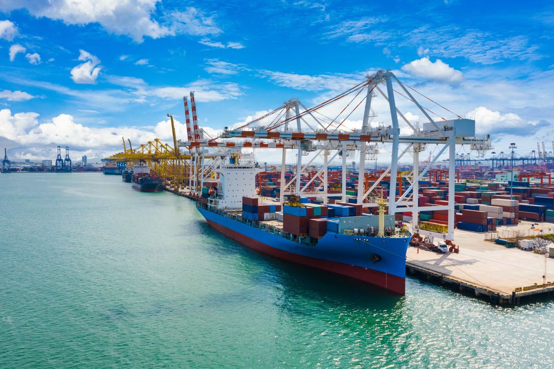 Real photo: a container ship being loaded by gantry cranes at a container port terminal